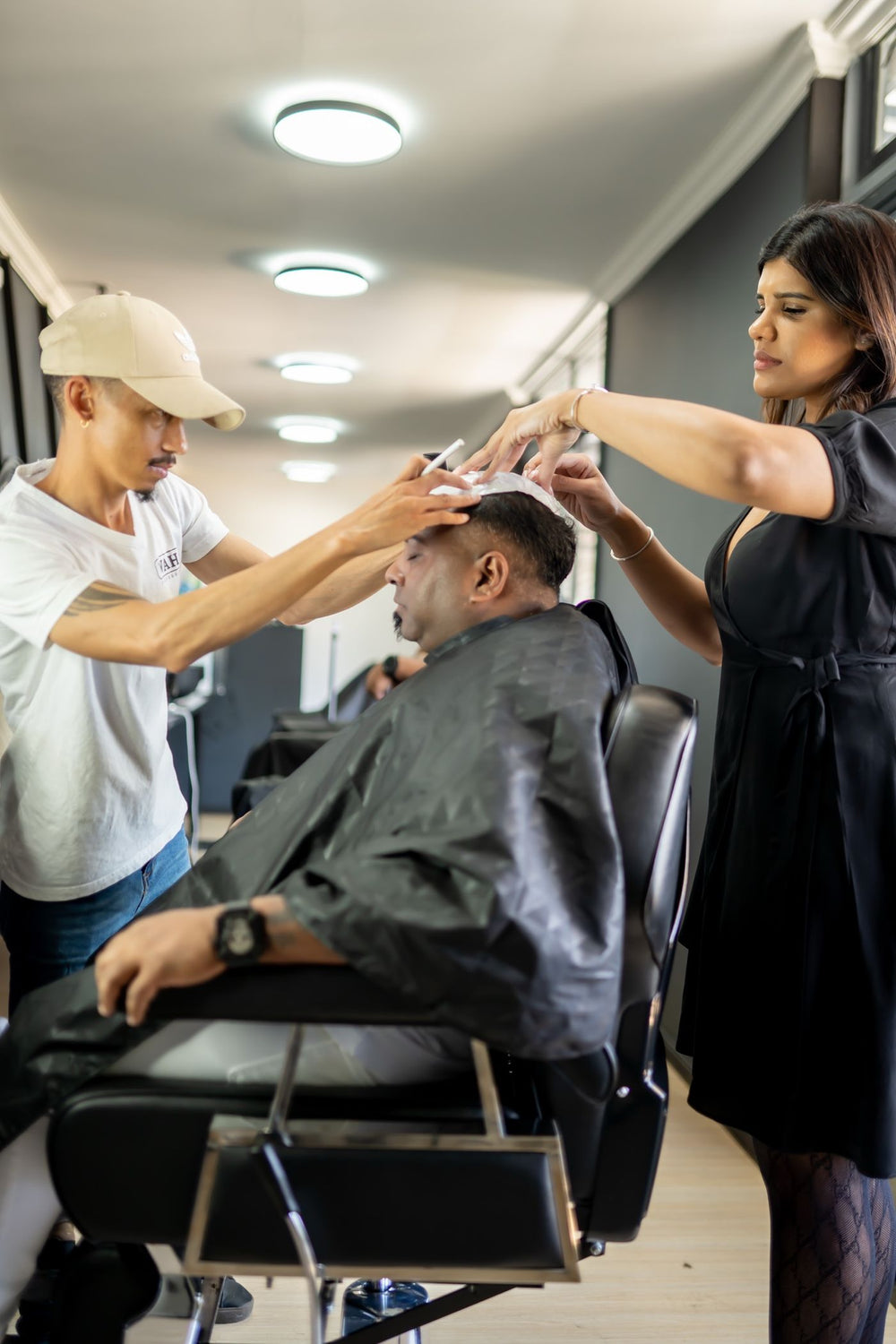 A hair system being fitted in a barbershop